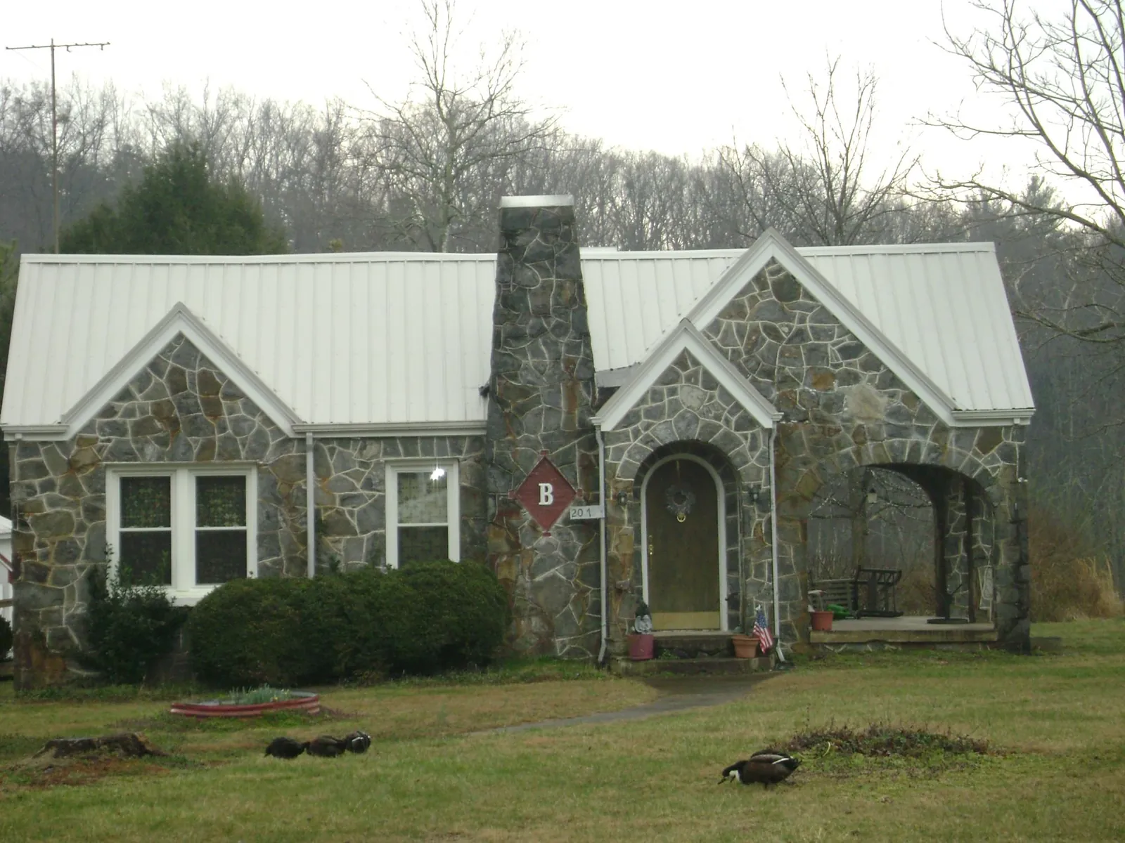White metal roof on a stone cottage with steep gables in Ligonier