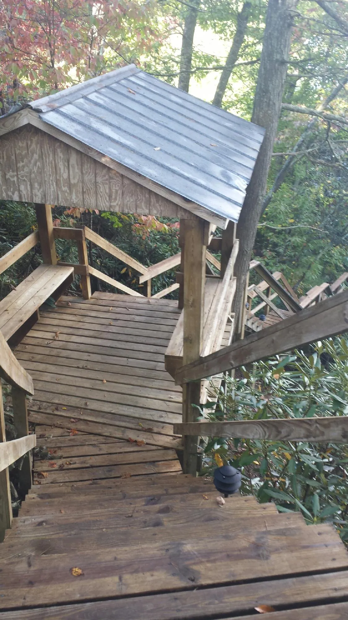 Metal roofed shelter over wooden steps on a wooded walkway — Skylight Repair & Installation work by our crew in Ligonier